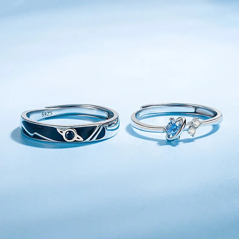 Dream Planet silver geometric couple rings with gem inlay on a flat surface