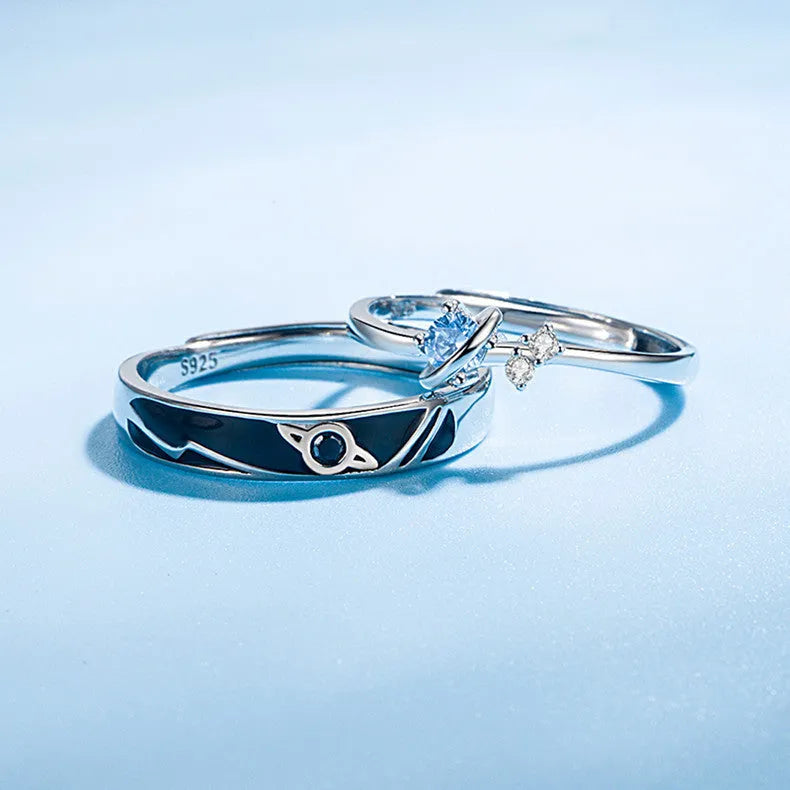Dream Planet silver geometric couple rings with gem inlay on a flat surface
