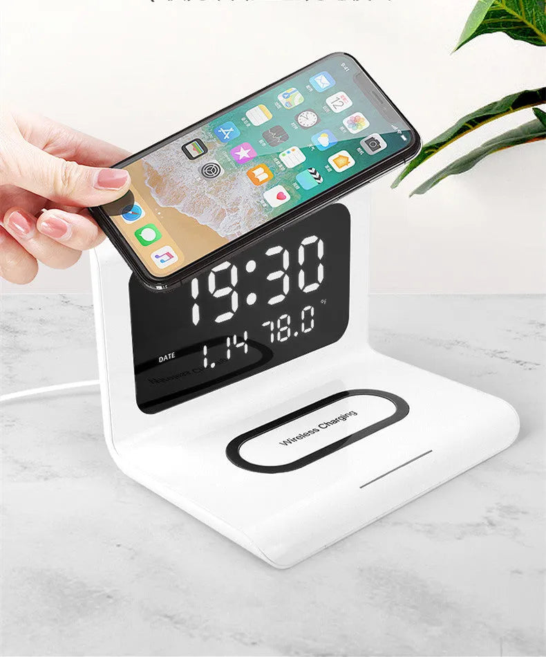 White wireless charger alarm clock showing time, date and temperature display with phone charging on surface