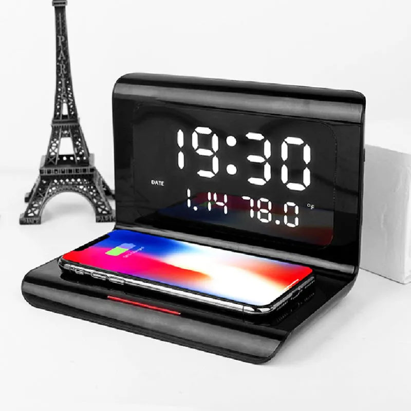 White wireless charger alarm clock showing time, date and temperature display with phone charging on surface