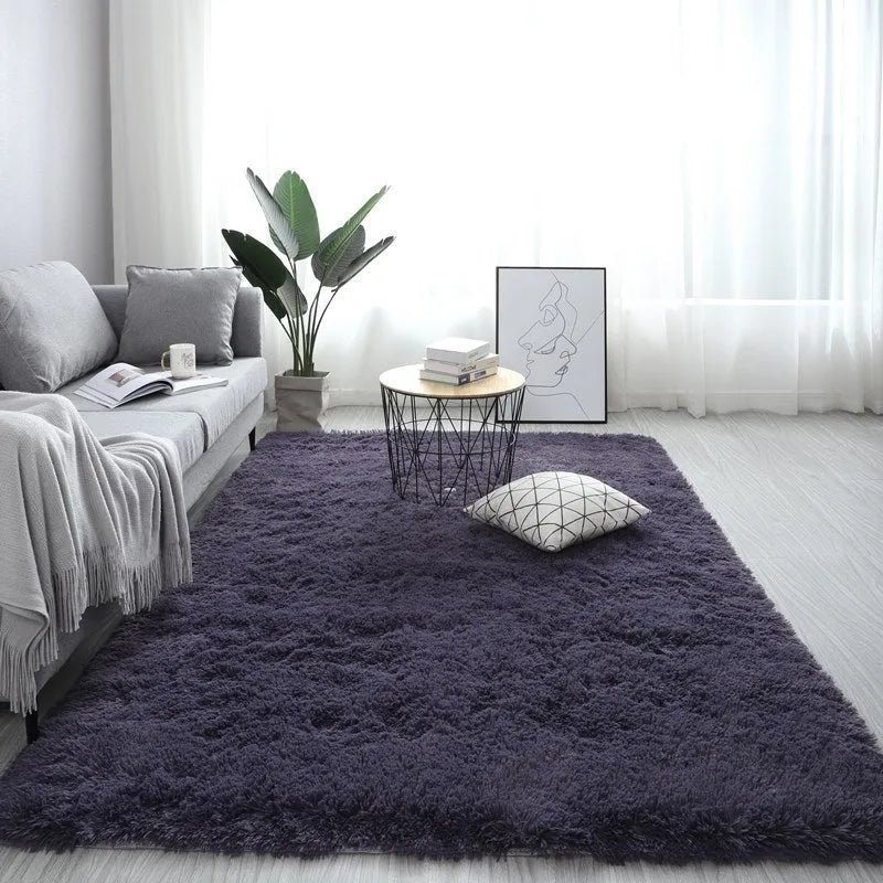 Large rectangle fluffy plush carpet with anti-slip backing in a light grey colour on a wooden floor