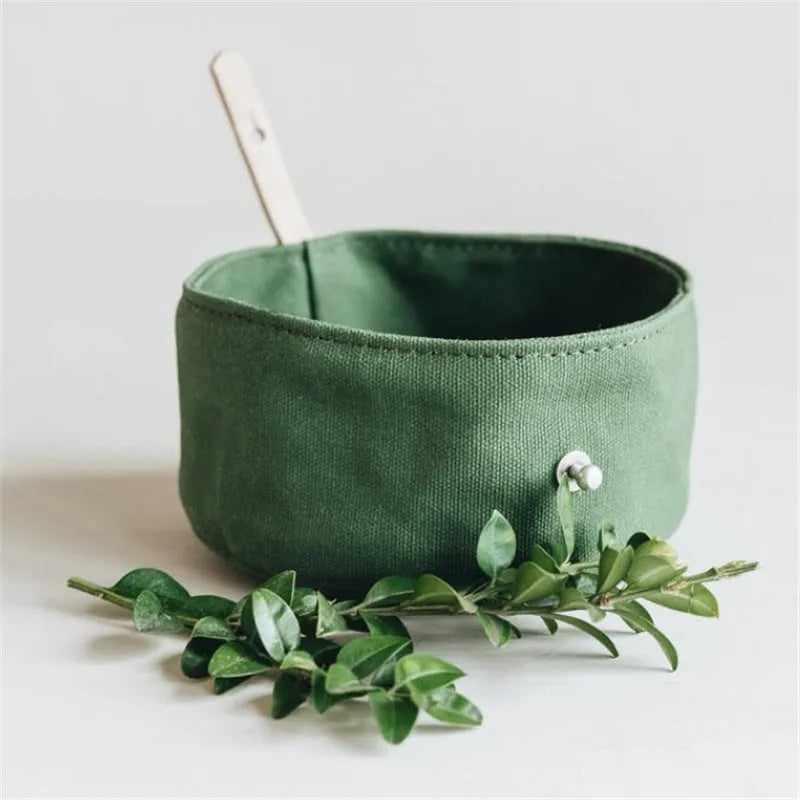Waterproof foldable travel dog bowl in oil wax canvas, round shape, 150x75mm, shown in green or grey