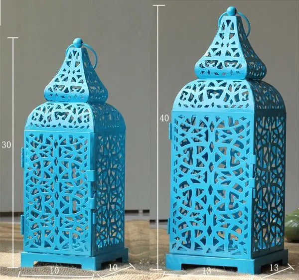 Blue geometric Moroccan-style metal lantern candle holder on a wooden table.