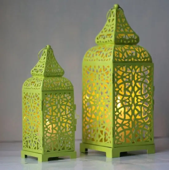 Blue geometric Moroccan-style metal lantern candle holder on a wooden table.