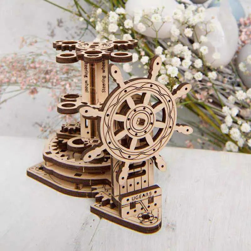 Wooden rotating pen holder with a turning steering wheel model on a desk.