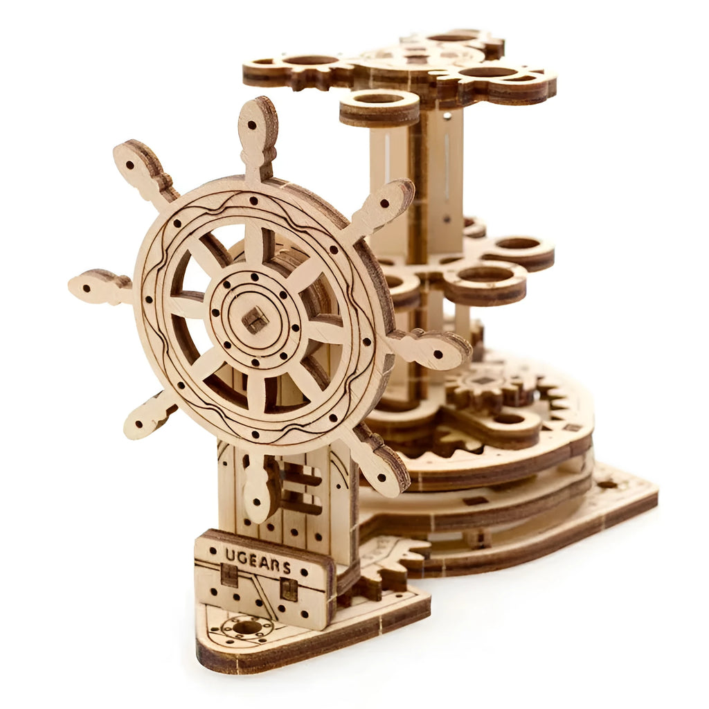 Wooden rotating pen holder with a turning steering wheel model on a desk.