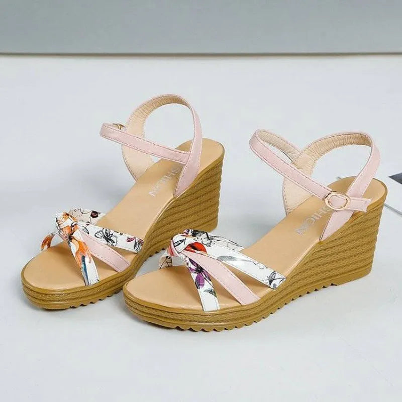 Women's pink wedge sandals with a thick heel, fish mouth design, and a buckle strap.