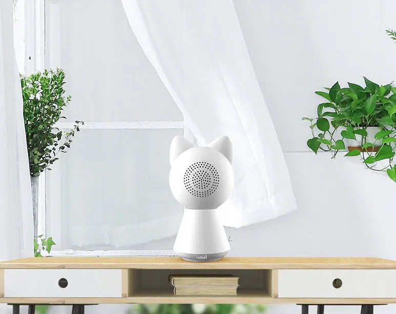 White wireless WiFi PTZ security camera on a table with a mobile phone showing its live feed.