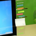 Clear acrylic computer monitor side pane note board measuring 28x7.8cm attached to a monitor