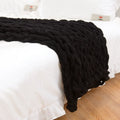 Handmade coarse yarn knitted chenille blanket with thick yarn, cable stitching, beige colour, folded decoratively