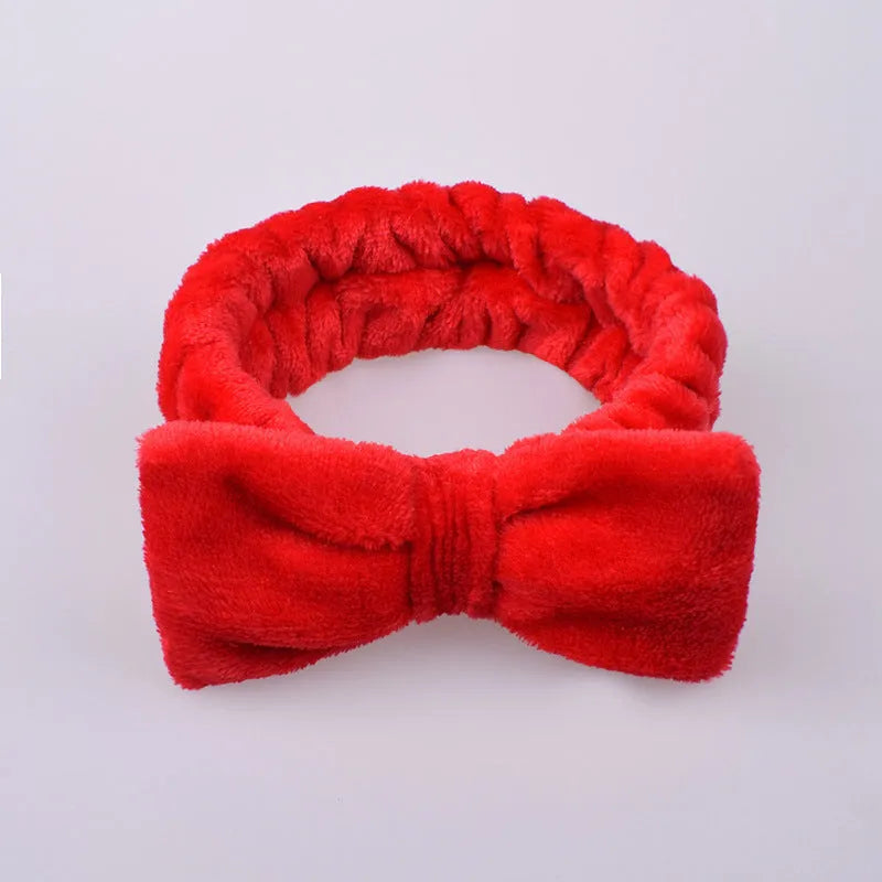 Coral velvet butterfly end hair band with letter text design in pink colour on neutral background