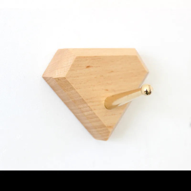 Beech wood and brass adhesive wall hook in one of five shapes: round, capsule, oval, diamond, or square.