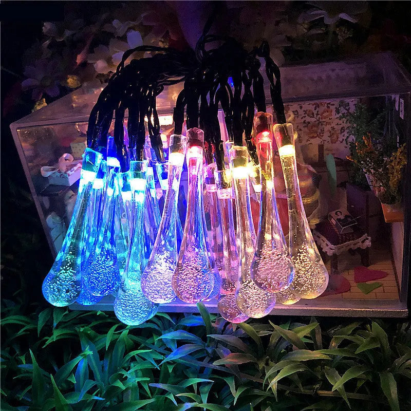 6.5 metre long solar-powered outdoor LED string lights with bubble drop pendants on a garden fence