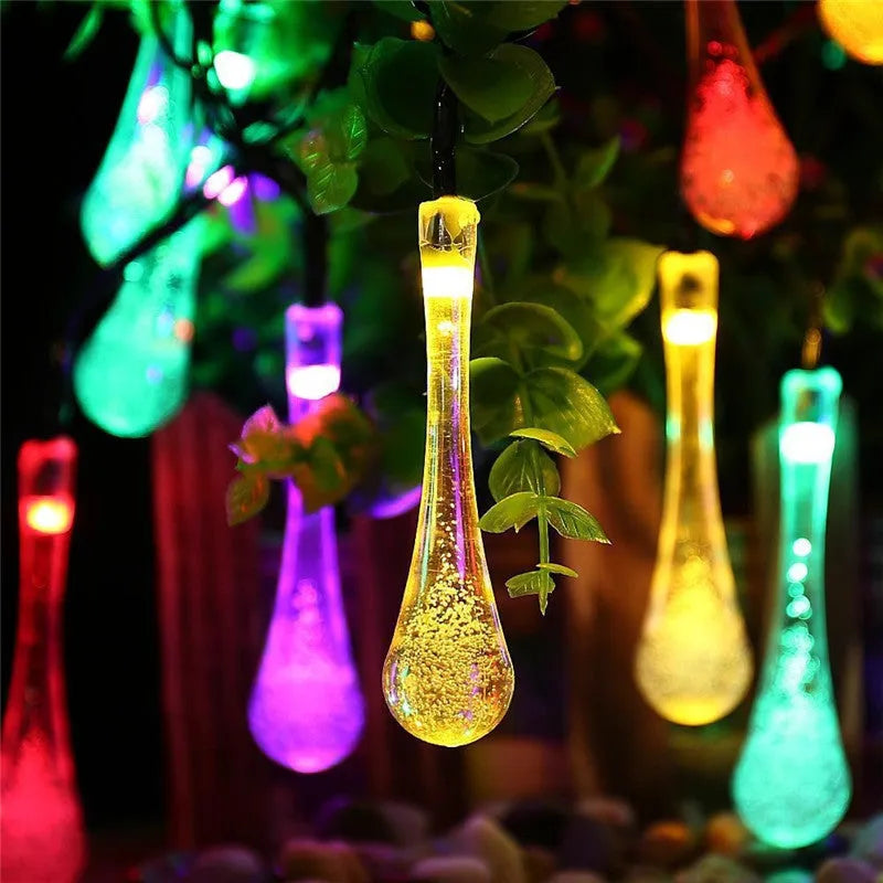 6.5 metre long solar-powered outdoor LED string lights with bubble drop pendants on a garden fence