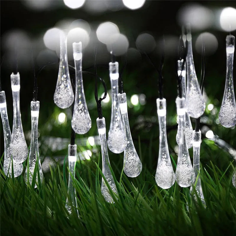 6.5 metre long solar-powered outdoor LED string lights with bubble drop pendants on a garden fence