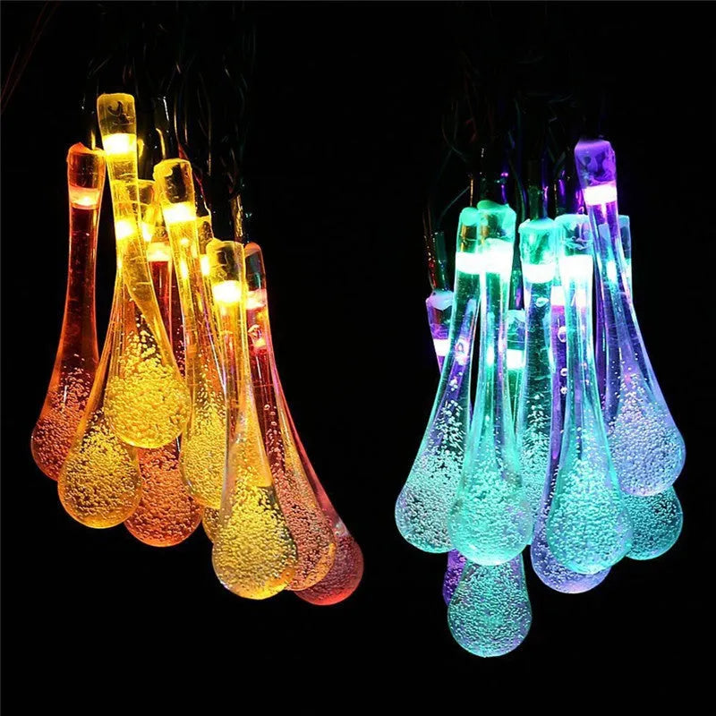 6.5 metre long solar-powered outdoor LED string lights with bubble drop pendants on a garden fence
