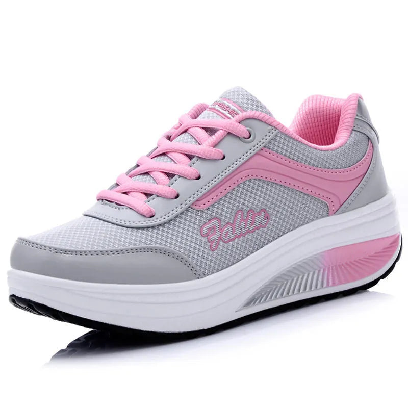 Women's grey and black casual sports shoes with a medium heel on a plain background