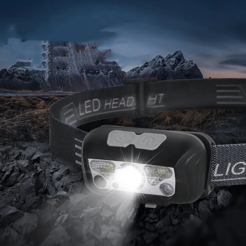 Black USB rechargeable headlamp with sensor switch and red LED running lights on a headband