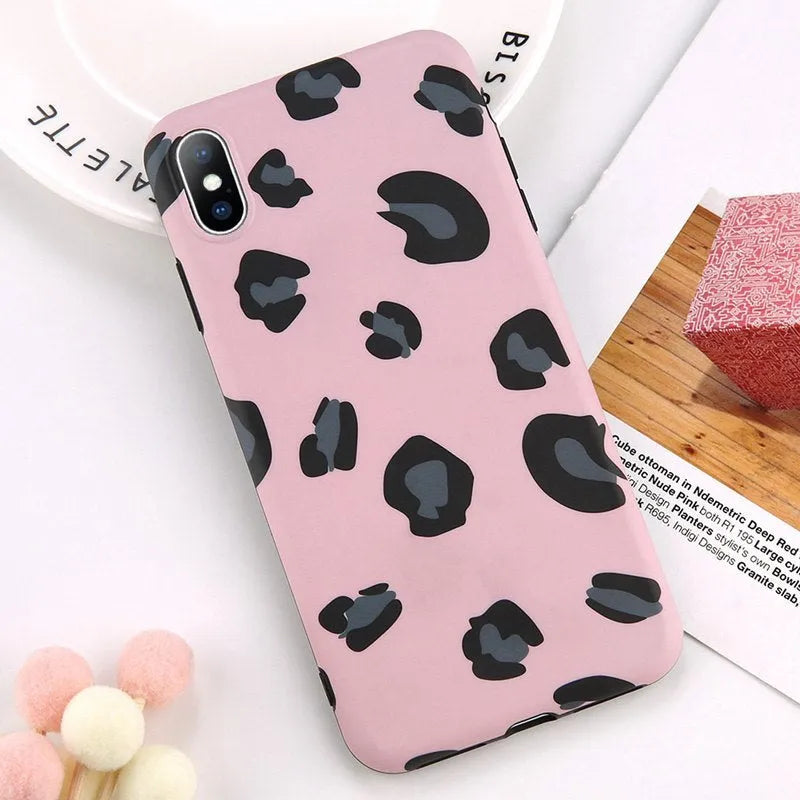 Leopard print pattern phone case for iPhone models on a table.