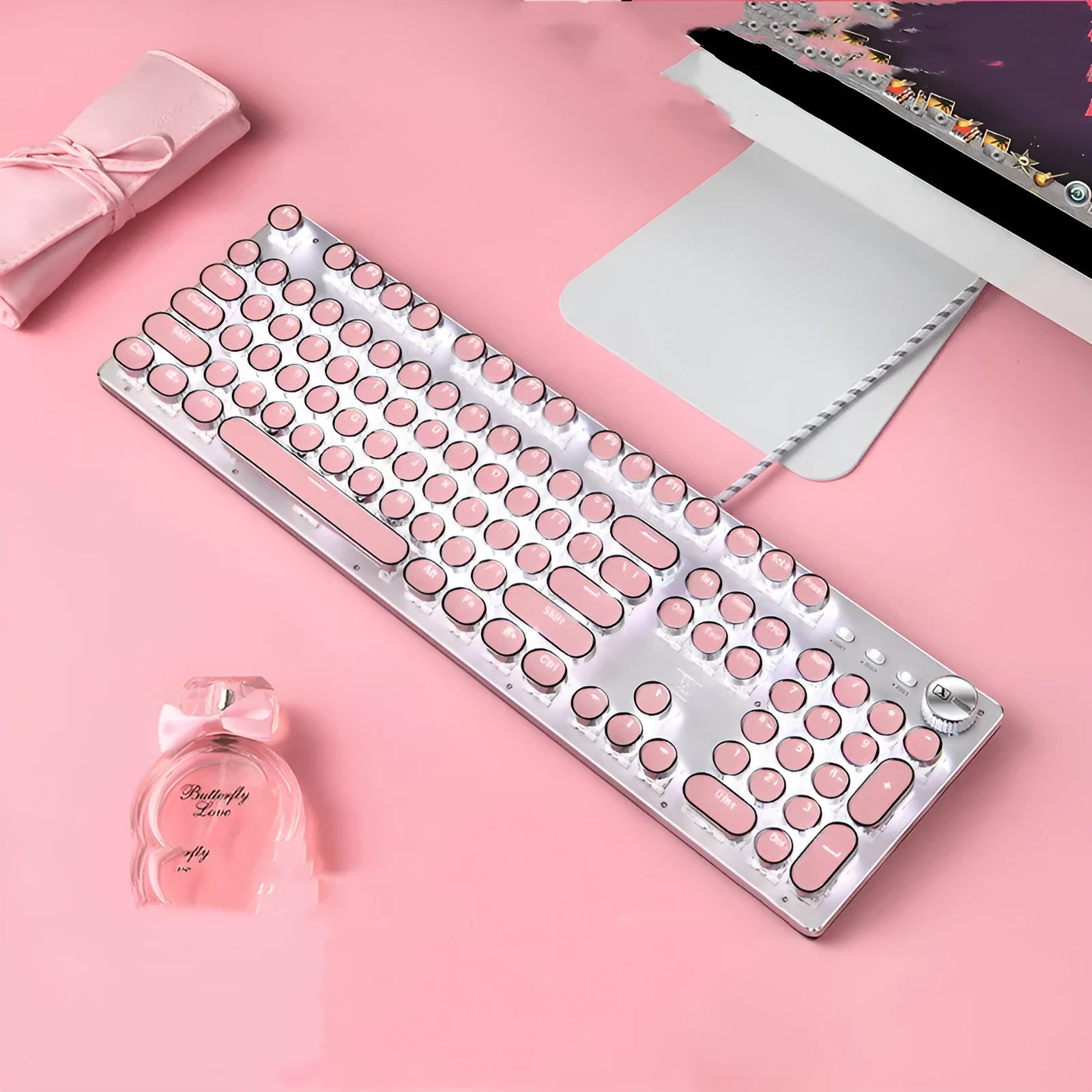 Pink and silver mechanical keyboard with green switches and matching wireless mouse on a desk.