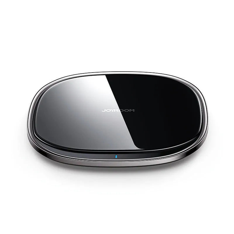 Black 15W Qi wireless fast charger with zinc alloy frame and glass top on a desk.