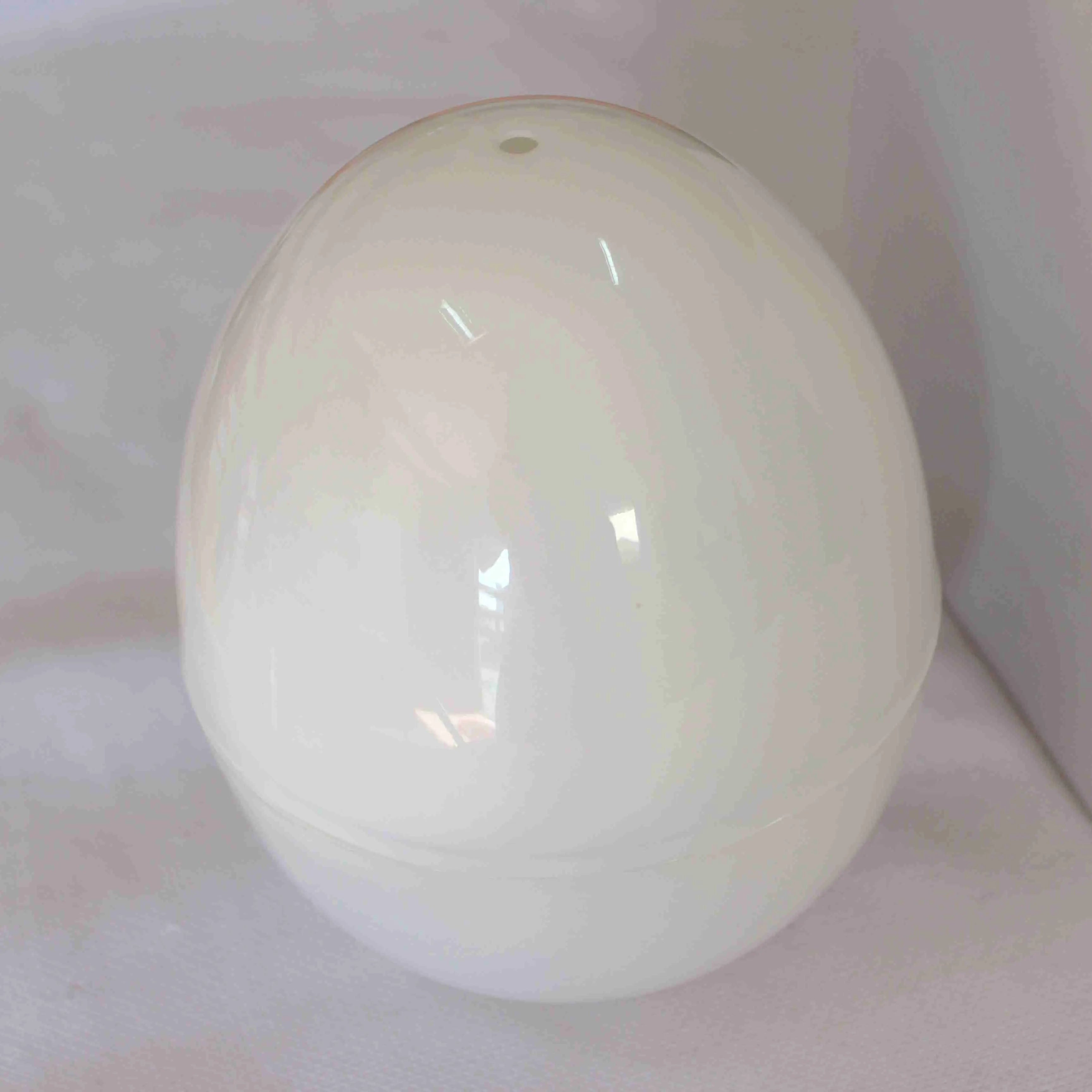 White microwave egg cooker with capacity for four eggs on a kitchen counter.