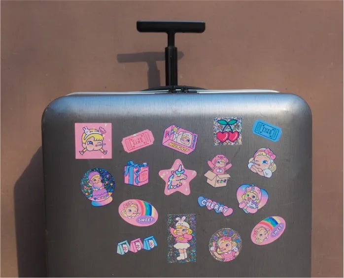 Cartoon sticker set showing 16 square PVC decals and storage box with cute girl and comic designs.