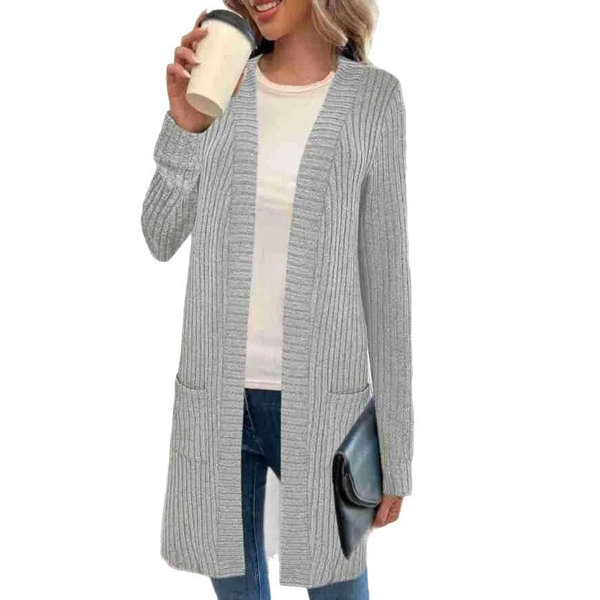 A woman wearing a loose-fit long sleeve knitted cardigan jacket with pockets, available in black, grey, or wine red.