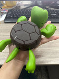 Turtle-shaped ABS plastic coaster in light green colour on table