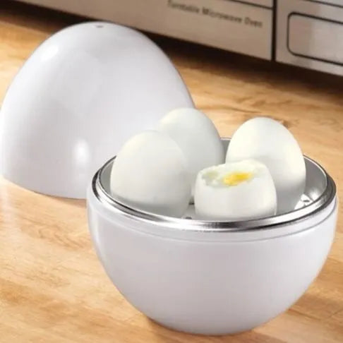 White microwave egg cooker with capacity for four eggs on a kitchen counter.