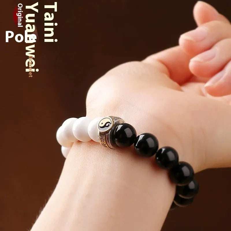 Black and white taiji bracelet with woven obsidian beads showing six word mantra and bagua symbol