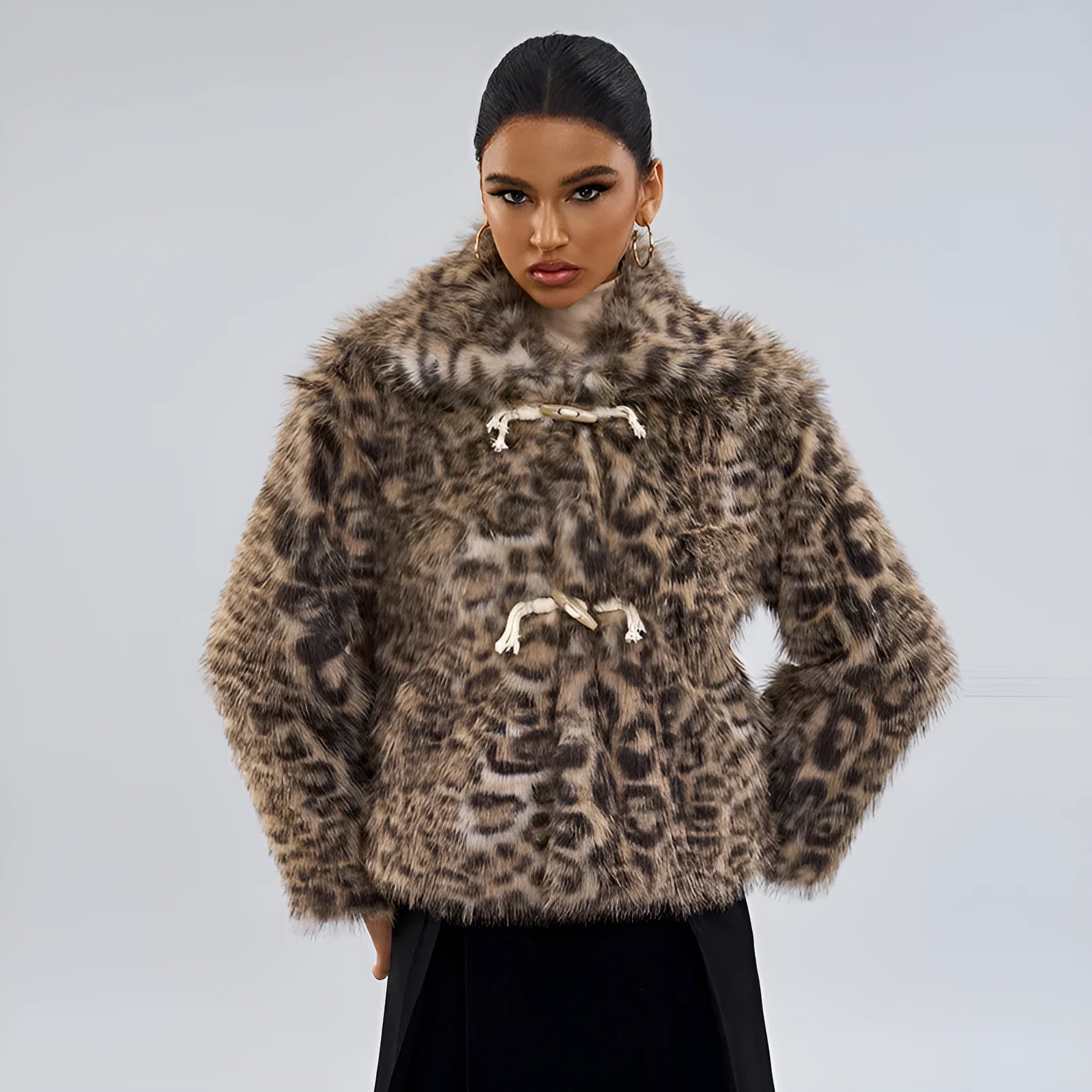 Women's leopard print coat with a buckle lapel, shown in street fashion style.