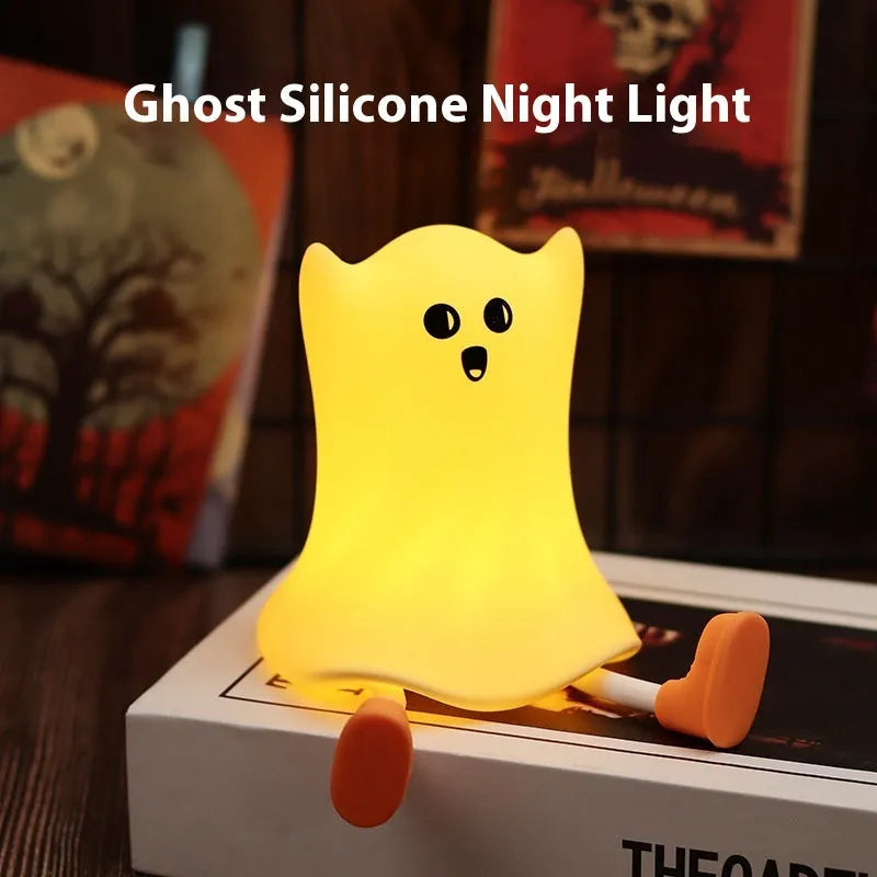 Cartoon ghost-shaped silicone bedside lamp with touch control, soft yellow glow on a bedside table