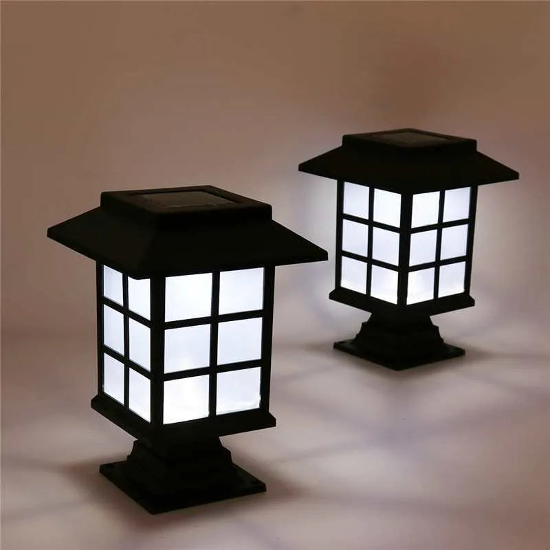 Black solar outdoor LED lawn light with window-style apertures emitting soft white or warm white light