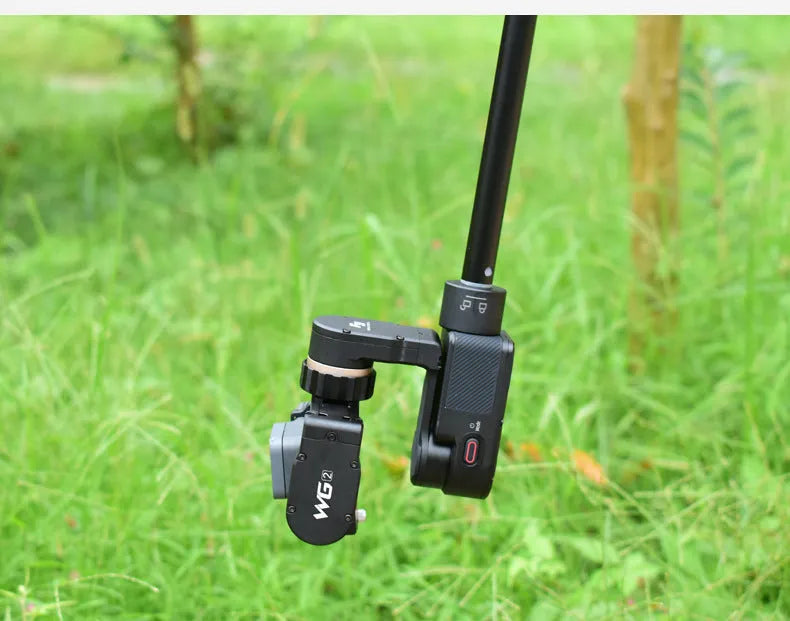 Black retractable selfie stick extended to full length with phone attached, showing detachable tripod legs and wireless remote.