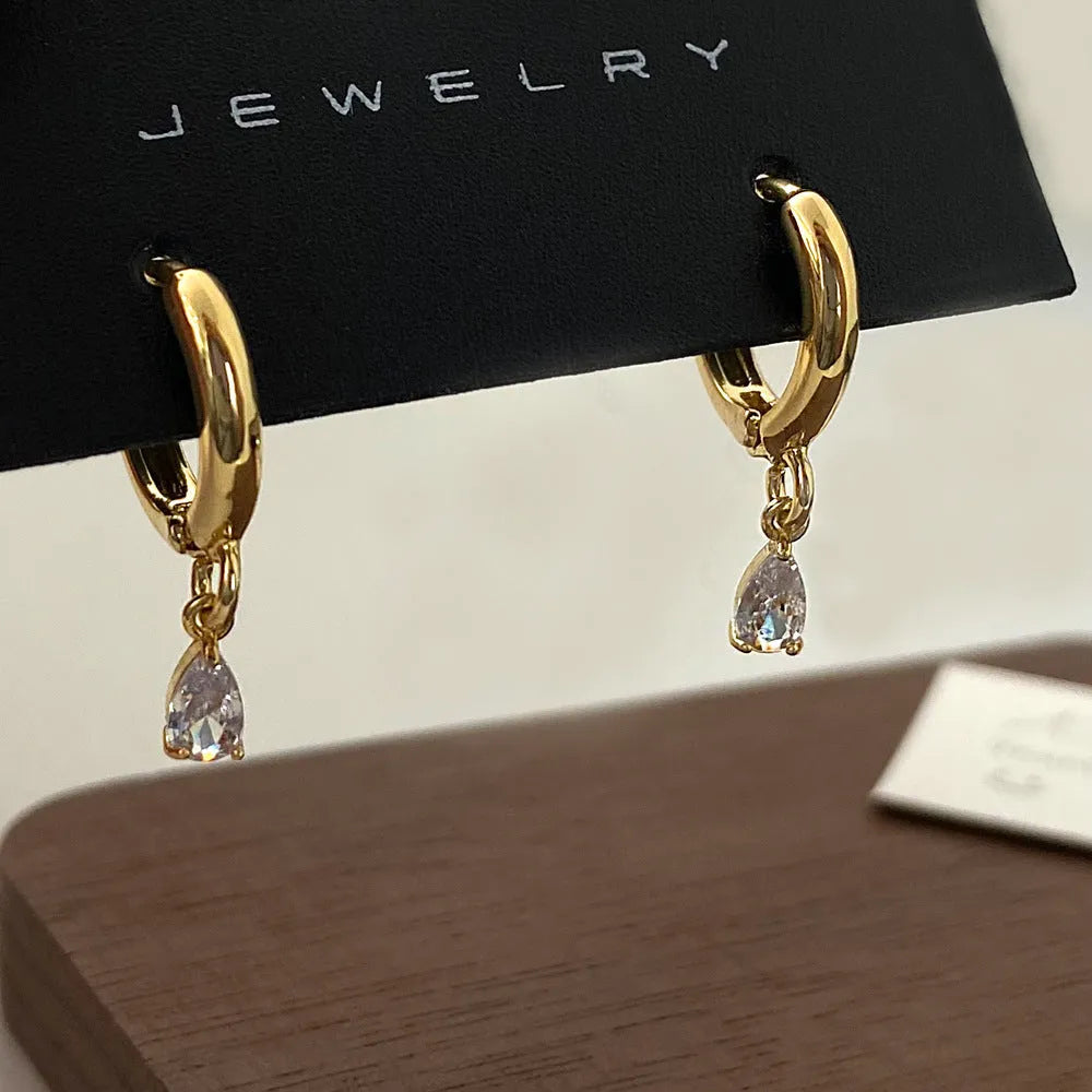 A women's zircon jewellery set showing a geometric meteor shower necklace, matching earrings, and an anklet on a white background.