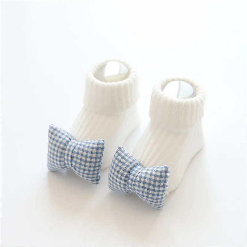 Cotton baby floor socks in a pink bow pattern, shown on an infant's feet.