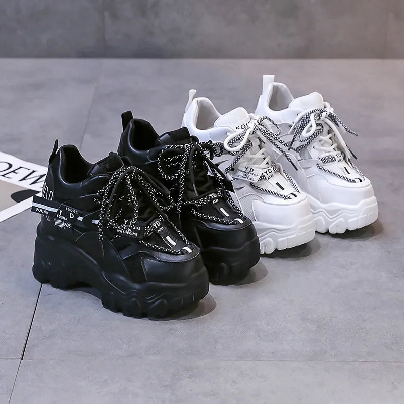 White women's platform sports shoes with mesh upper, cross strap, and a thick rubber sole.