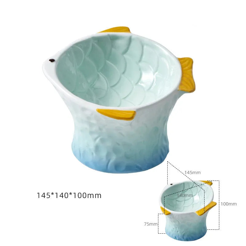Set of four blue, fish-shaped ceramic cat bowls with a tilted design on a kitchen counter.
