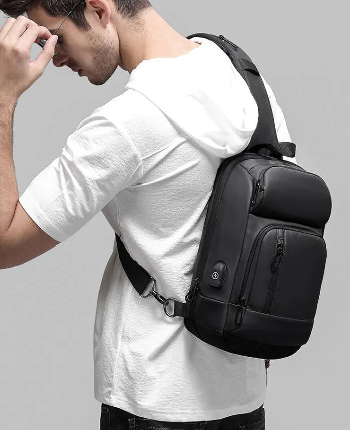 Black PVC outdoor shoulder bag showing internal laptop pocket and air cushion shoulder strap.