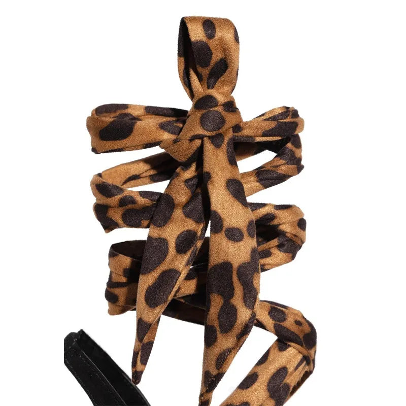 Light brown women's high heel sandals with leopard print and criss-cross ankle straps.