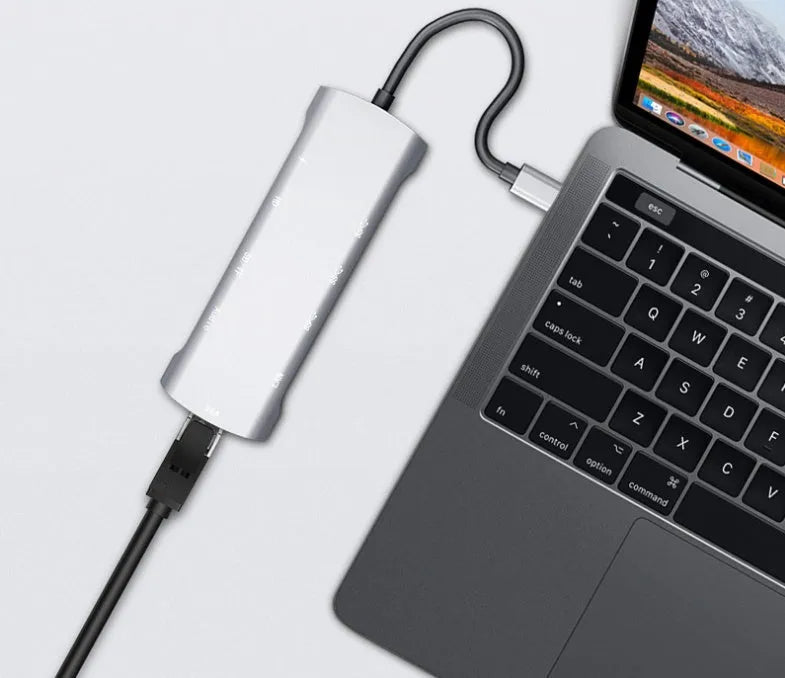 Grey aluminium USB-C docking station with HDMI, VGA, and USB ports.