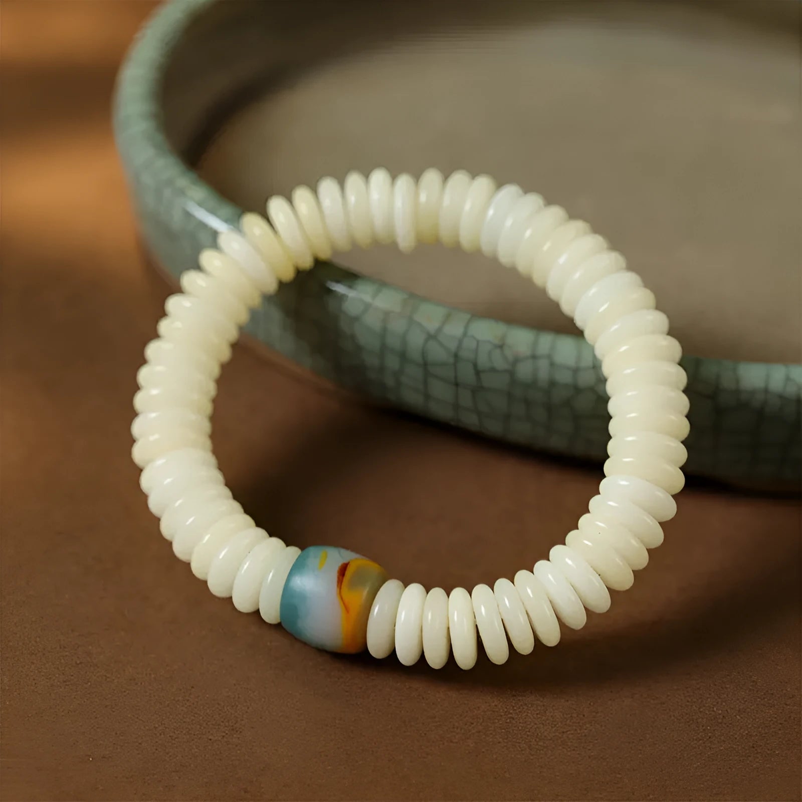 A white Bodhi seed bracelet shown in both a looped wrist style and a straight handheld style.
