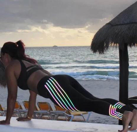 Women's black high-waisted workout leggings with night glowing print pattern on legs