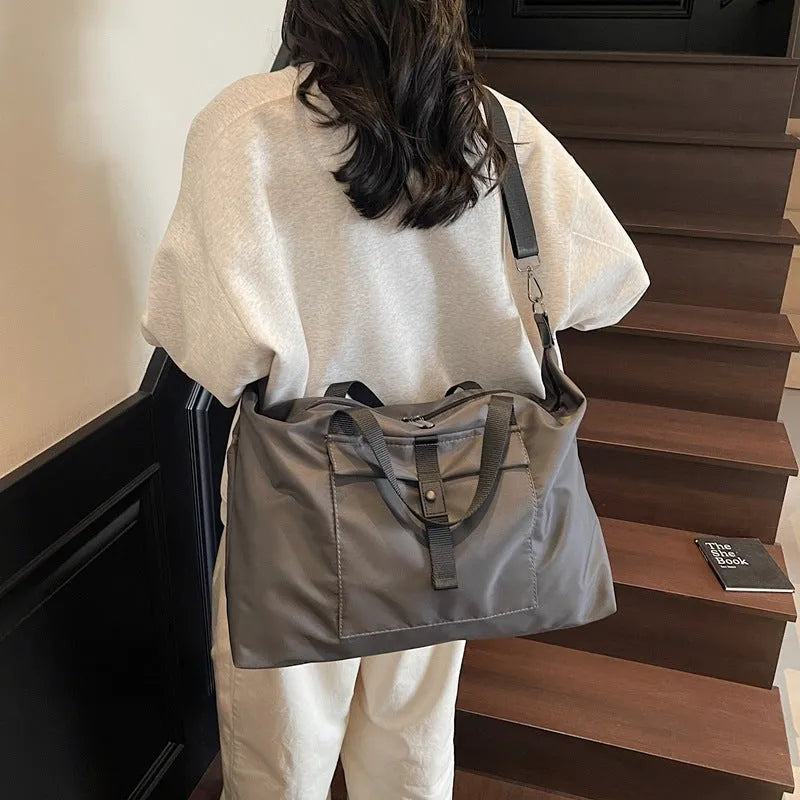 Grey one-shoulder travel bag with 36-55L capacity showing Oxford cloth construction