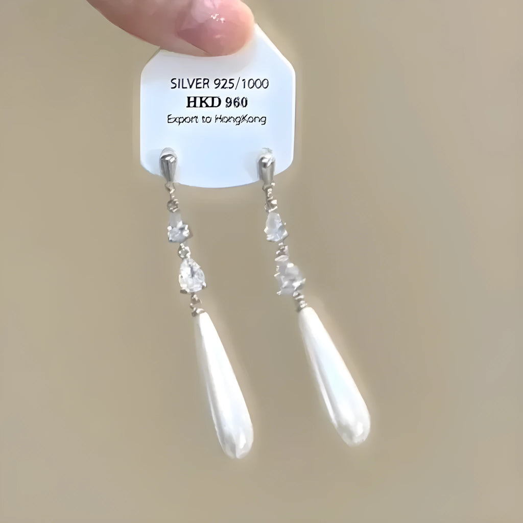 Close-up of a women's geometric alloy ear clip with rhinestones, a star charm, and a tassel on a white background.