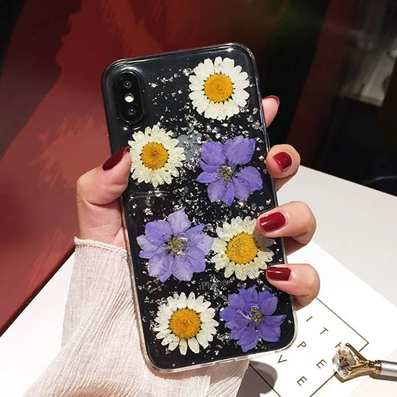 Clear handmade TPU iPhone case with pink dried flowers encased in epoxy resin on the back.