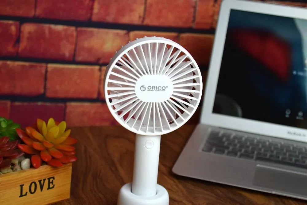 White ORICO FH1 portable USB rechargeable small fan on a desktop.
