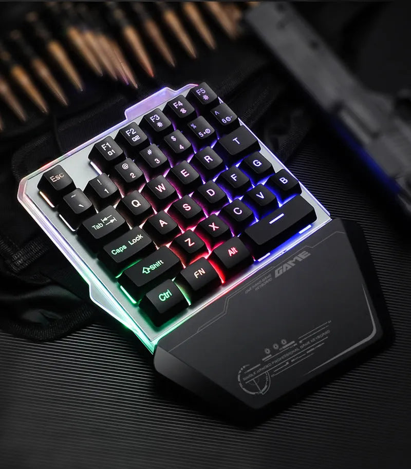 Black robotic one-handed mechanical keyboard with RGB backlit keys on a desk.
