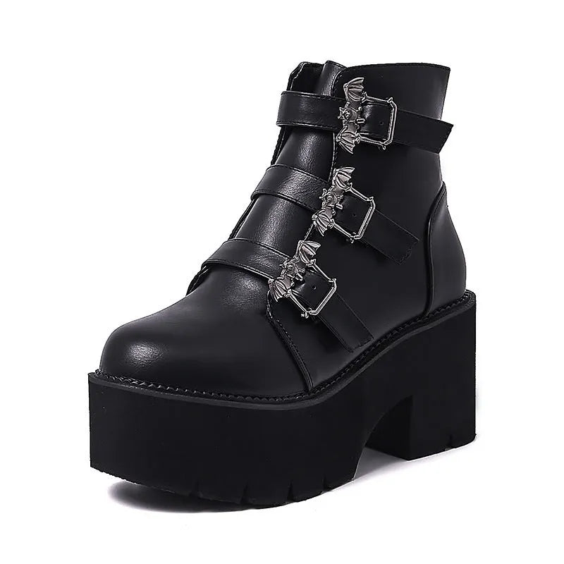 Black women's punk ankle boots with bat buckle and side zip on a thick sole.